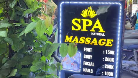 Hanoi,-Vietnam---Spa-Massage-Schild-Mit-Blinkenden-Lichtern-Und-Preisen-Menschen-Im-Hintergrund-Zu-Fuß