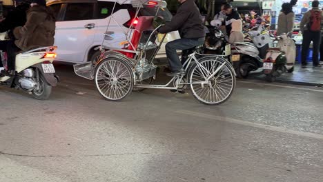 Busy-Hanoi-street-in-Vietnam---scooter-mopeds-cyclos---side-view-passing-vehicles