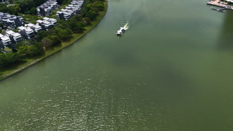 Drone-shot-of-a-tourist-ferry-driving-on-the-Putrajaya-Lake,-in-sunny-Malaysia