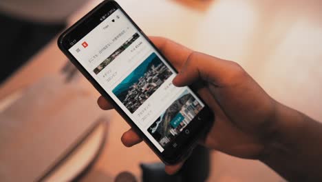 Closeup-shot-of-hands-of-an-unrecognizable-young-modern-man-surfing-his-mobile-smartphone