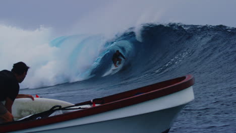 Surfer-Schneidet-Zurück-In-Die-Welle-Und-Zieht-Sich-Mit-Der-Hand-übers-Gesicht,-Während-Zuschauer-Vom-Boot-Aus-Zusehen