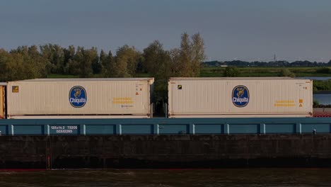 Branded-goods,-river-transportation,-Dutch-landscape-background,-aerial