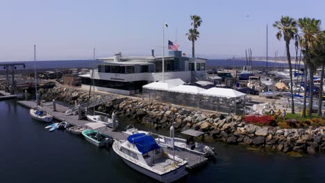 Rising-and-panning-aerial-shot-of-the-King-Harbor-Yacht-Club-in-Redondo-Beach,-California