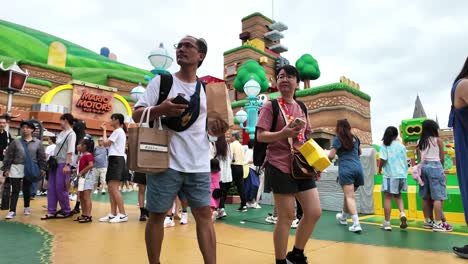 People-walking-through-and-exploring-vibrant-Mario-World-themed-area-at-Universal-Studios-Japan