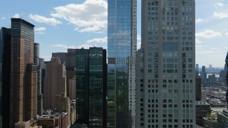 Drone-flying-toward-skyscrapers-in-Midtown,-Manhattan,-sunny-day-in-New-York,-USA