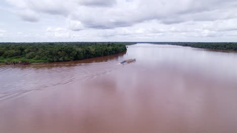 Aerial:-Boat-pushing-large-pontoon-floating-platform-in-the-jungle-river,-green-background