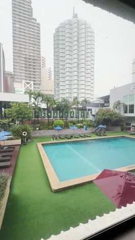 landscape-view-of-swimming-pool-in-the-resorts-and-nearby-skyscraper-building