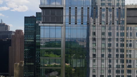 Antena:-Central-Park-Reflejándose-Desde-Un-Rascacielos-En-El-Soleado-Centro-De-La-Ciudad,-Manhattan,-Nueva-York