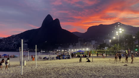 Menschen,-Die-Bei-Orangefarbenem-Sonnenuntergang-Am-Strand-Von-Ipanema-Spazieren-Gehen-Und-Sport-Treiben