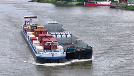 VRIDO-Cargo-Ship-Sailing-In-The-River-In-Alblasserdam,-Netherlands---Aerial-Drone-Shot