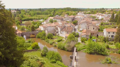 Parthenay,-Una-Ciudad-Fortificada-Medieval-En-Francia-Con-Exuberante-Vegetación-Y-Un-Río,-Vista-Aérea