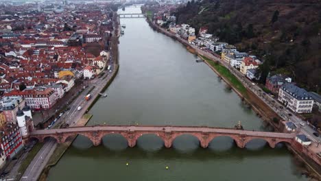 Descending-jib-reveal-of-Heidelberg-Bridge-and-city-Skyline,-Aerial