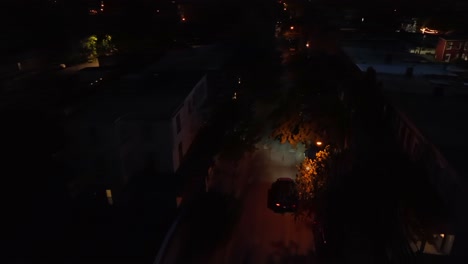 Night-scene-with-driving-car-on-street-in-american-neighborhood