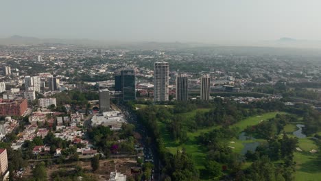 Drohne:-Colomos-Park-In-Der-Stadt-Guadalajara-An-Einem-Sonnigen-Tag-Und-Gebäude