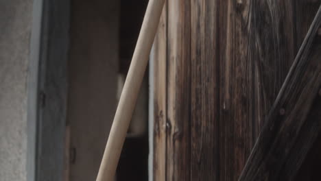 Handheld-close-up-shot-of-grabbing-a-wooden-scythe