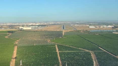 Einzigartiger-Blick-Auf-Den-Schatten-Eines-Jets,-Der-Sich-Der-Landebahn-Des-Flughafens-Sevilla-Nähert,-Aufgenommen-Aus-Dem-Cockpit-Mit-Warmem-Licht-Und-Einem-Wolkenlosen-Blauen-Himmel