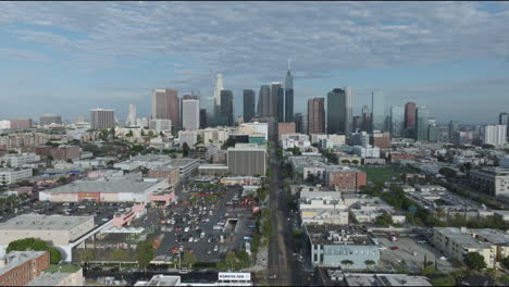 Drone-Shot-of-Iconic-Downtown-Los-Angeles-Cityscape-Flying-Backwards-Over-Urban-Neighborhood