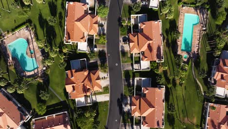 Luxurious-homes-in-Palm-Springs-California-USA-with-pools-and-long-shadows-from-trees,-drone-top-down-overview