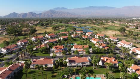 Aerial-pullback-above-townhomes-looking-out-over-Palm-Springs-California-USA-with-mountains-in-background