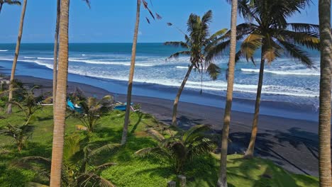 Aerial-reveal,-beautiful-coastal-scenery,-white-water-waves,-jukung-boats