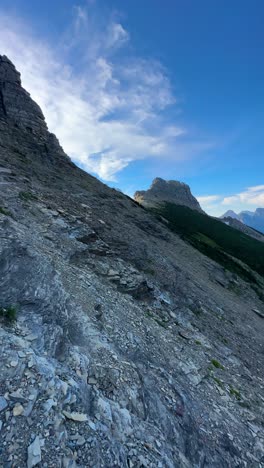 Vertical-View,-Woman-Hiking-on-Highline-Trail,-Glacier-National-Park,-Montana-USA