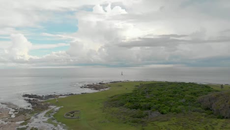 Un-Barco-Navegando-Suavemente-A-Lo-Largo-De-La-Pintoresca-Costa