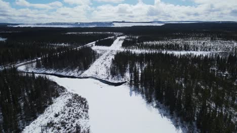 Winter-Forest-With-River-And-Highway-Near-Kiruna-In-Norrbotten,-Sweden