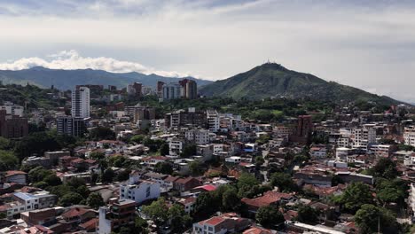 Drone-view-of-West-Cali's-Normandy-neighborhood,-Colombia,-Three-Crosses-Hill-in-background