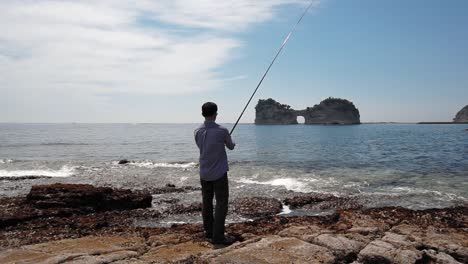 Fishing-man-at-the-beach,-Shirahama-district,-slow-motion-24fps-out-of-50fps