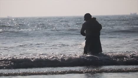 Silhouette-Der-Fischer,-Die-Bei-Sonnenuntergang-Fischernetze-Ins-Meer-Werfen