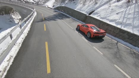 Ferrari-in-the-alps-driving-fast-along-a-mountain-road