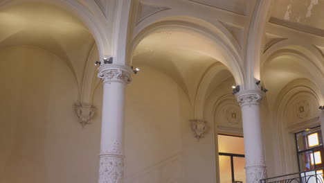 Elegant-arches-and-columns-inside-Dunkirk-Town-Hall,-France,-lit-with-warm-lighting