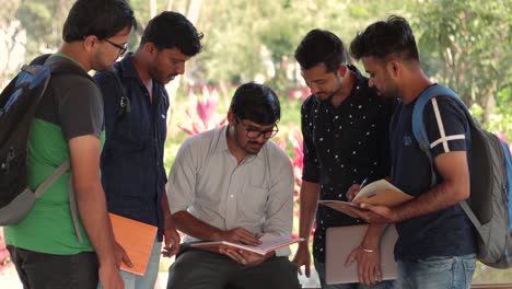 Group-of-students-discussing-at-college---happy-young-people-talking-about-the-task-at-university-campus---Intelligent-student-in-class-explaining-to-his-friends