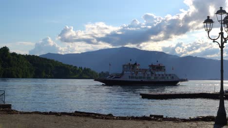 Ferry-En-El-Lago-Maggiore-Acercándose-A-Laveno-Mombello,-Varese,-Italia-Durante-La-Puesta-De-Sol