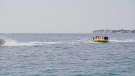 Tracking-shot-of-inflatable-tube-dragged-by-speedboat-in-Croatia