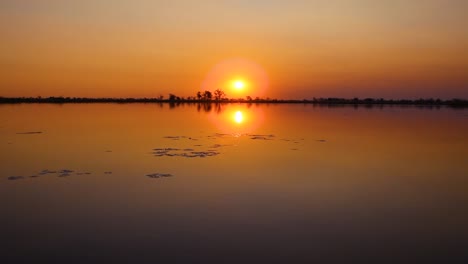 Puesta-De-Sol-Sobre-Un-Lago-Con-La-Silueta-De-árboles-En-Botswana