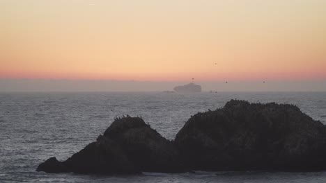 Close-View-of-Rock-Formations-With-a-Passing-Cargo-Ship-in-the-Distance