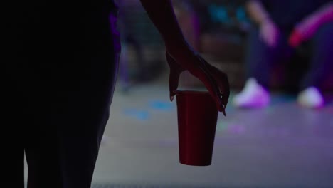 woman-with-red-cup-in-hand-comes-to-the-party-in-slow-motion