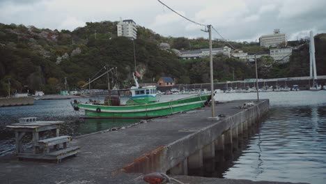 Barco-Pesquero-Verde-Atracado-En-Un-Muelle-Deportivo-En-Saikazaki,-Japón