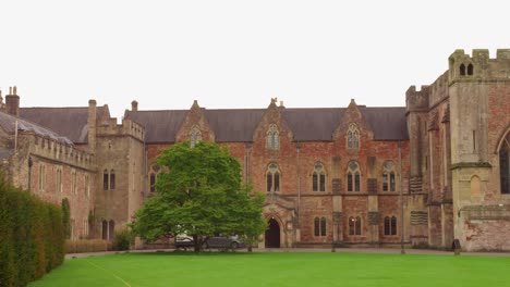 View-of-old-medieval-architecture-of-Bishop's-Palace-with-Chapel-and-green-Croquet-Lawn-in-Wells,-England-during-daytime