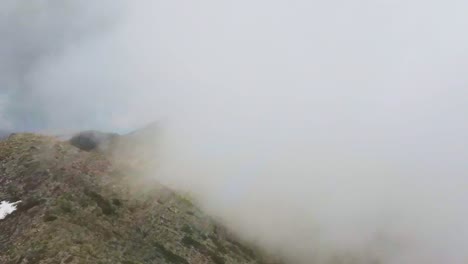 Woman-walking-among-clouds-on-mountain-ridge-White-Mountains-Crete