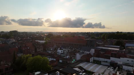 Drone-flying-above-the-city-of-Roeselare,-Belgium-at-sunset