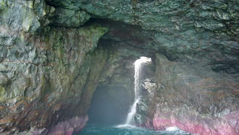 4K-Hawaii-Kauai-Boating-on-ocean-medium-shot-drifting-toward-waterfall-in-cave