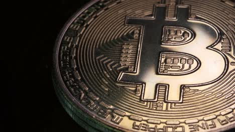 4K-Kryptomünze-In-Bitcoin-Währung,-Die-Sich-Langsam-Im-Uhrzeigersinn-Mit-Reflektierendem-Licht-Vor-Schwarzem-Hintergrund-Dreht