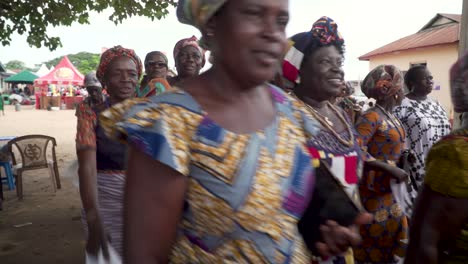 Women-joyful-dance-and-wave-white-handkerchiefs-at-a-celebration-festival-in-Ghana,-West-Africa