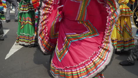 A-Woman-dancing-at-the-Day-of-the-Dead-parade-in-Mexico-City-wearing-a-traditional-colourful-Mexican-dress