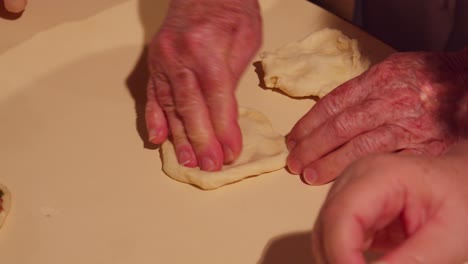 Grandmother-senior-hands-kneading-raw-dough,-family-cooking-in-slow-motion