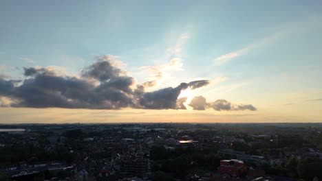 Sunset-at-Roeselare,-Belgium,-Sun-behind-clouds,-creating-a-cinematic-view-of-the-city-of-Roeselare