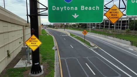 Sun-Reflection-on-green-street-sign-with-Daytona-Beach-on-interchange-highway-in-USA