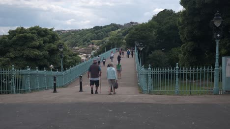 Aufnahmen-Der-Spa-Bridge-In-South-Bay,-Scarborough,-North-Yorkshire-An-Einem-Sommertag-An-Einem-Geschäftigen-Wochenende-Mit-Menschen,-Die-über-Die-Brücke-Laufen